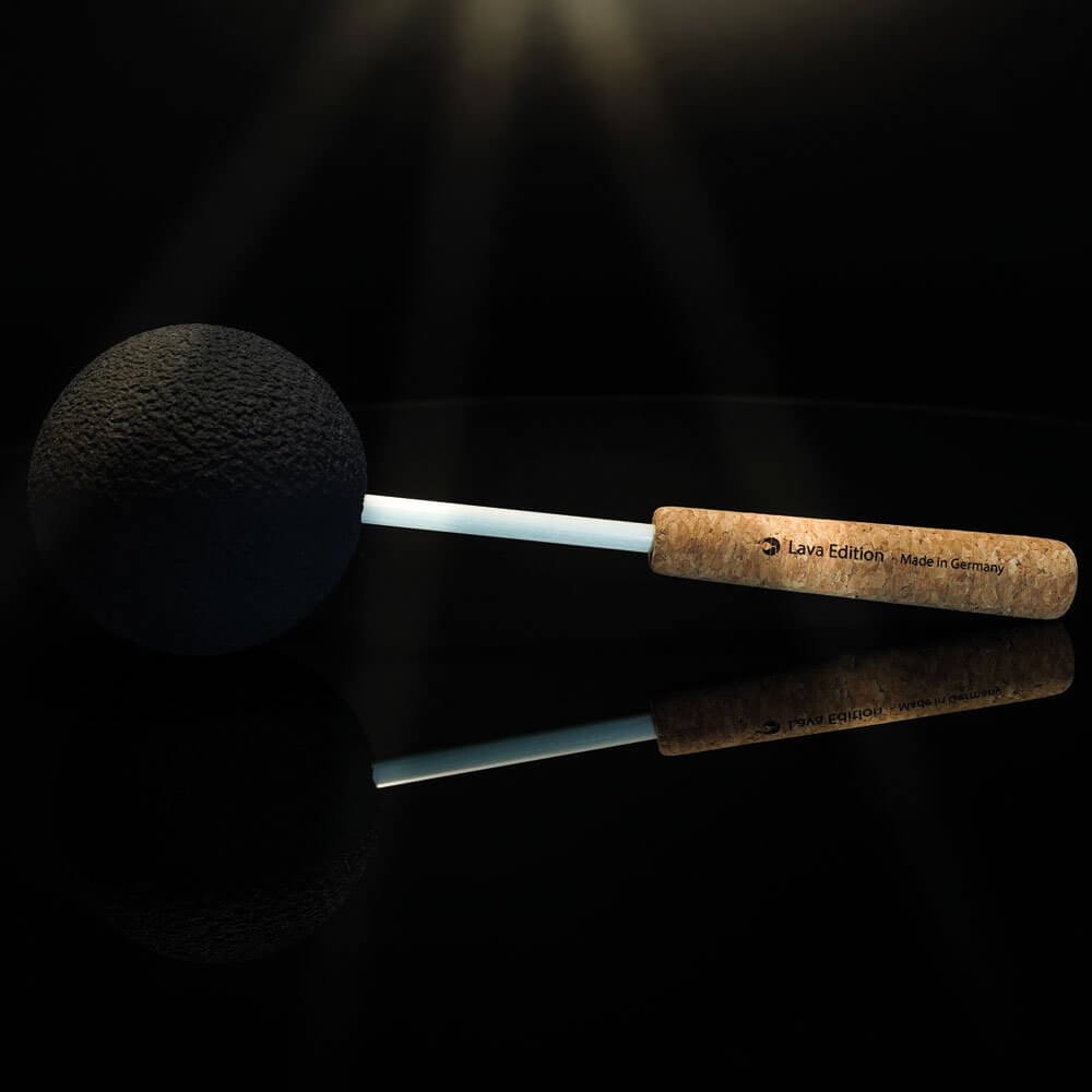 Gongreiber Lava Edition 70mm with cork handle on a glossy black surface, bathed in an atmospheric beam of light