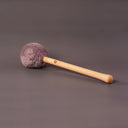 Mallet des Monats mit altrosafarbenem Fleecekopf und hellem Holzgriff auf grauem Hintergrund
