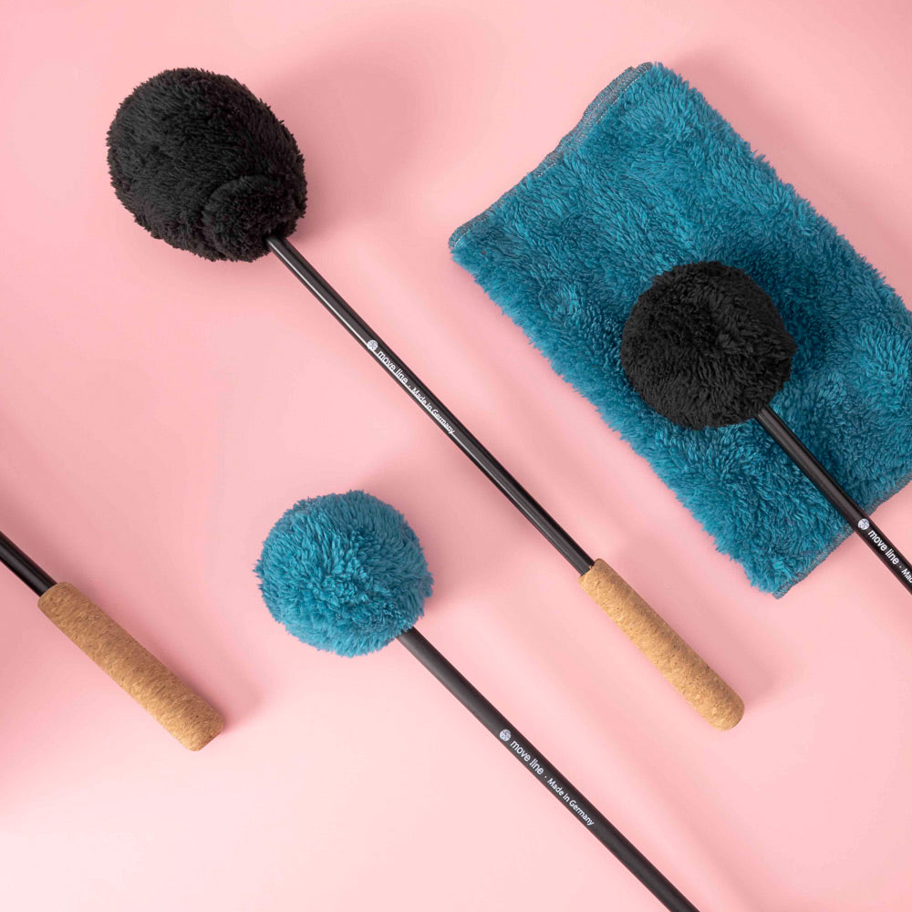 Profi Gong Mallets "Move Line" Edition with black and teal plush heads and cork handles on a pink background